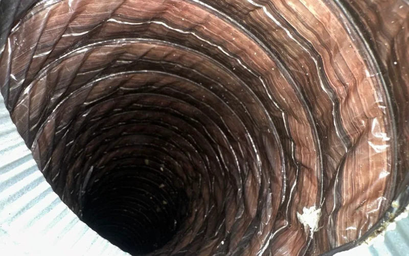 Inside a flexible supply duct, showing the film of dust built up along the liner